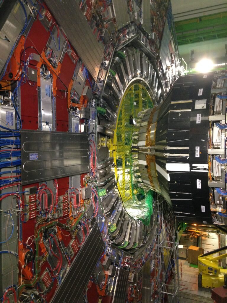 Interior view of the CMS detector cavern at the Large Hadron Collider, showing the layered calorimeters and muon chambers used to track particles
